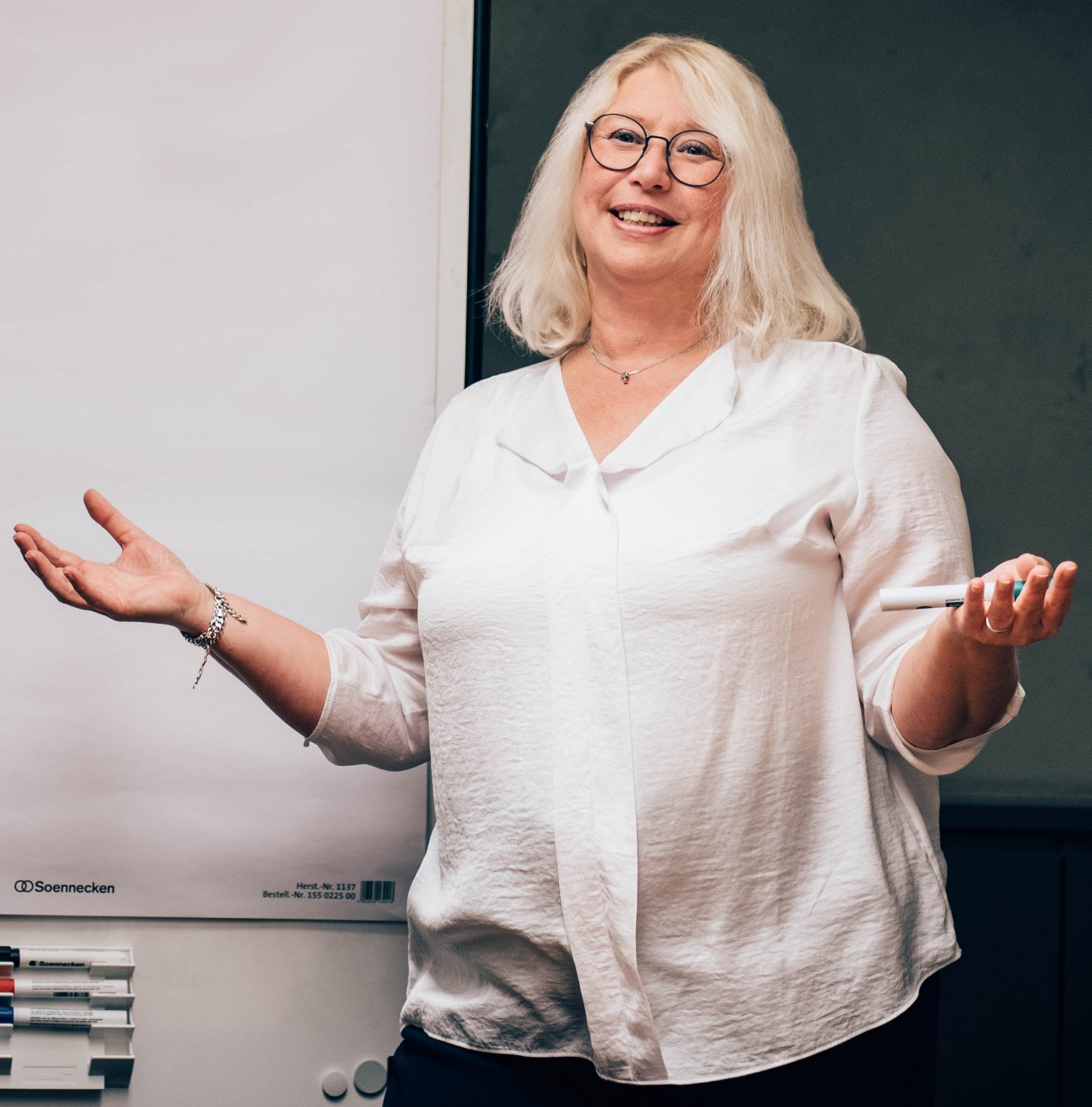 Gabi Brill in einem Seminar, mit offener Geste vor dem Flipchart